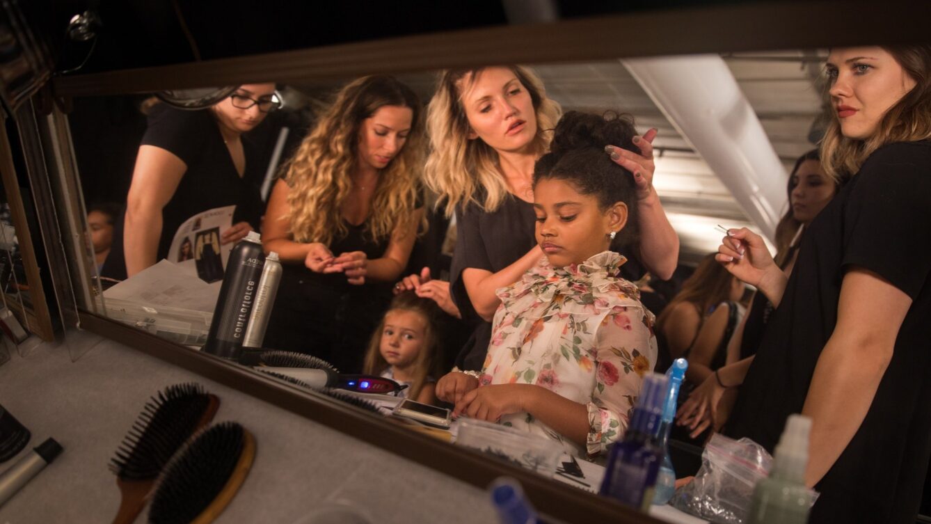 Young girl getting ready with beauty team surrounding her