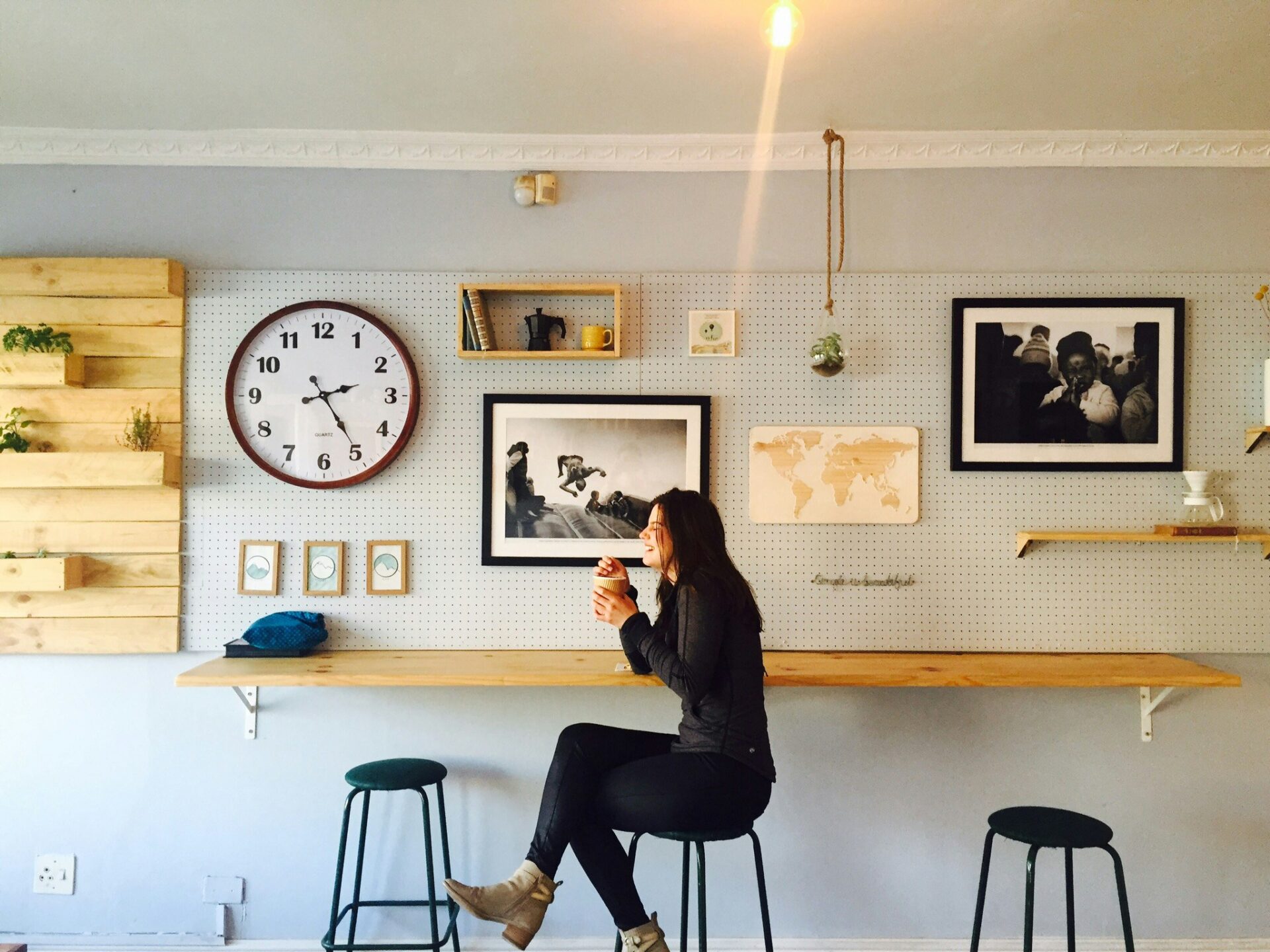 A woman laughing while sitting on a bar stool in a cafe