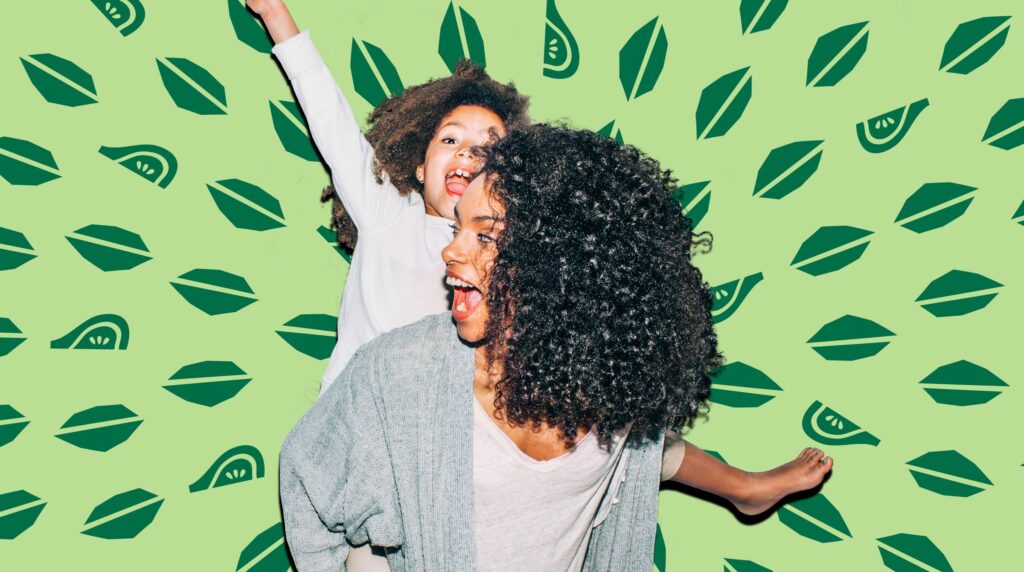 Mother giving daughter a piggyback ride in front of Nature's Bakery background